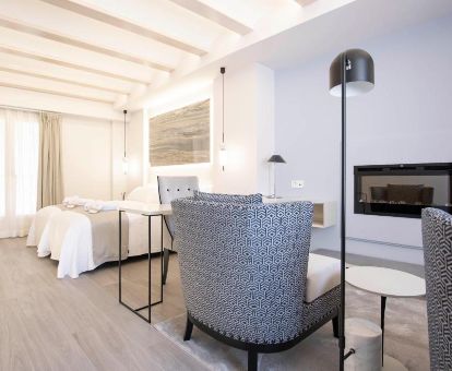 Amplia suite con sala de estar y chimenea en este moderno hotel solo para adultos.
