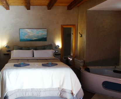 Foto de la Suite con bañera de hidromasajes junto a la cama.