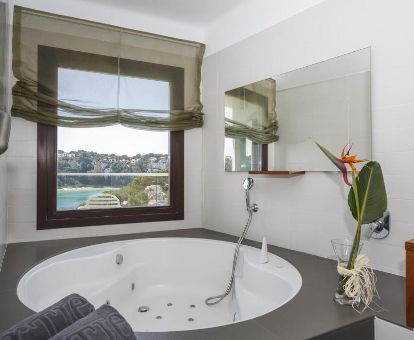 Bañera de hidromasaje privada de una de las habitaciones dobles con vistas al mar de este hotel solo para adultos.
