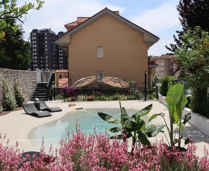 Agradable espacio exterior con piscina de tipo laguna y solarium de este hotel solo para adultos.