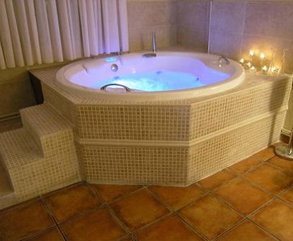 Foto de bañera de hidromasaje circular en habitación doble y habitacion con cama extragrande