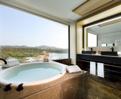 Bañera de hidromasaje privada con fabulosas vistas de la suite superior de este elegante hotel para parejas.