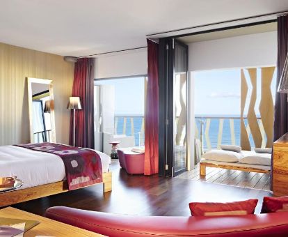 Una de las elegantes habitaciones dobles con zona de estar y terraza con vistas al mar del hotel.