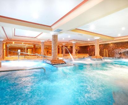 Gran piscina interior con hidroterapia del centro de bienestar del hotel.