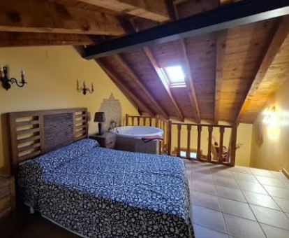 Foto del dormitorio con jacuzzi privado de una de las casas rústicas del alojamiento.