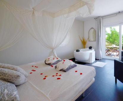 Foto de la Suite Doble con bañera de hidromasajes privada junto a la cama y chimenea.