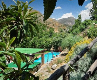 Piscina exterior situada ubicada en pleno jardín de la Casa Rural Las Huertas en Monachil