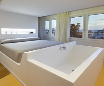 Foto de la habitación con bañera al lado de la cama en el hotel Granada Five Senses Rooms & Suites