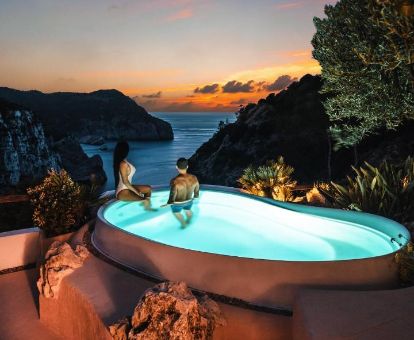 Pareja disfrutando de una piscina con maravillosas vistas al mar en este coqueto hotel romántico.