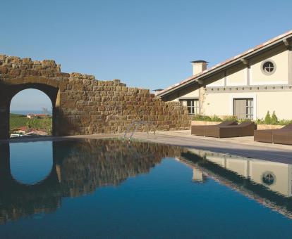 Foto de la piscina al aire libre del hotel con solarium y vistas a la naturaleza.