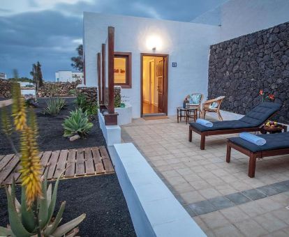 Terraza con mobiliario y acceso directo al jardín de este hotel solo para adultos.