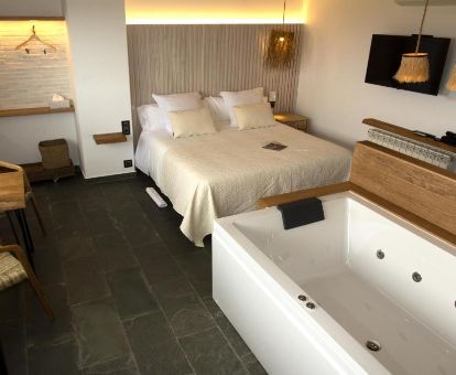 Habitación con cama grande y bañera de hidromasaje en este hotel solo para adultos.