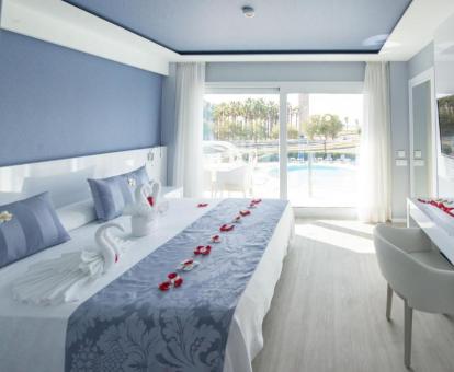 Foto de una de las elegantes habitaciones con balcón privado y vistas a la piscina y al mar.