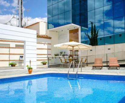 Foto de la piscina al aire libre del hotel con zona de tumbonas.