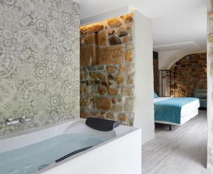 Suite Deluxe con bañera de hidromasaje privada y estilo rústico de este establecimiento ideal para parejas.