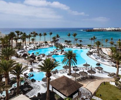 Hermosos exteriores con piscina de tipo laguna, solarium y vistas al mar de este hotel solo para adultos.