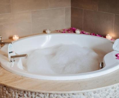 Bañera de hidromasaje privada con romántica decoración en la habitación doble deluxe del hotel.