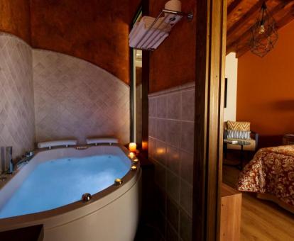 Bañera de hidromasaje privada de la suite con cama extragrande del hotel.