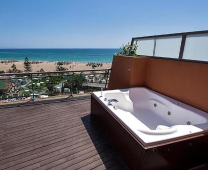 Terraza con bañera de hidromasaje privada y vistas al mar de una de las suites del hotel.