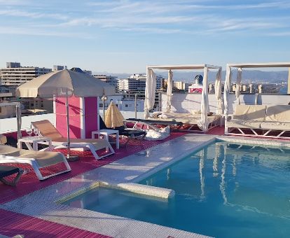Terraza solarium con mobiliario y piscina con vistas a los alrededores de este hotel solo para adultos.