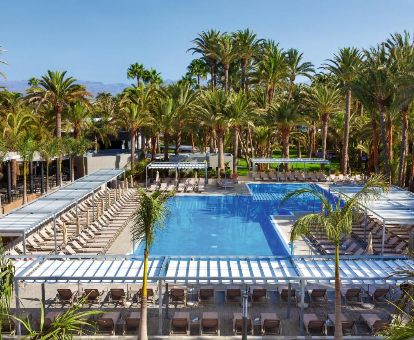 Exteriores de este elegante hotel ideal para parejas con piscina exterior rodeada de palmeras.