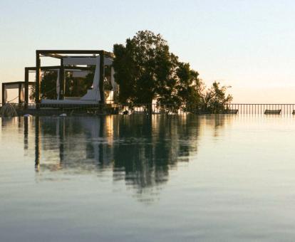 Foto de una de las amplias piscinas al aire libre con camas balinesas del hotel y hermosas vistas.