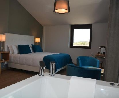 Hermosa suite con bañera de hidromasaje privada junto a la cama en este hotel solo para adultos.