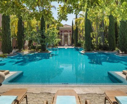 Foto de la piscina al aire libre del hotel con árboles y jardines.
