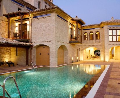 Edificio de piedra con piscina al aire libre de este acogedor hotel ideal para parejas.