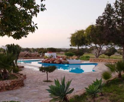 Foto de la piscina al aire libre disponible todo el año y rodeada de jardines de este establecimiento rural.
