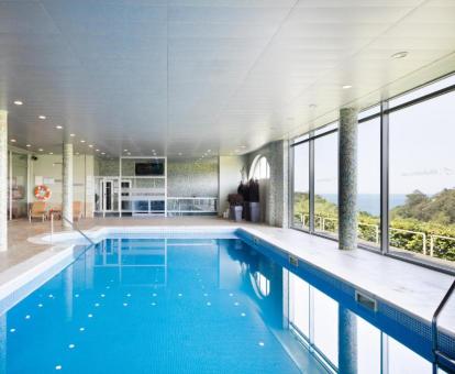 Foto de la piscina cubierta disponible todo el año con vistas a la naturaleza del hotel.