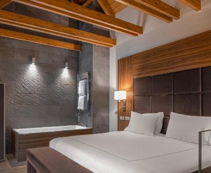 Hermosa suite dúplex con bañera de hidromasaje privada cerca de la cama de este hotel de montaña.