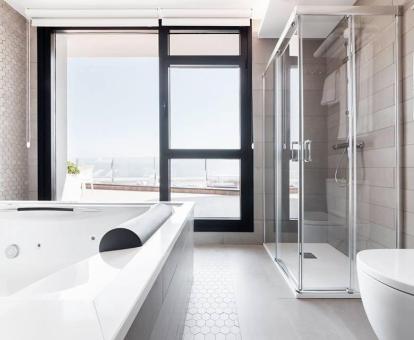 Foto del apartamento de un dormitorio con terraza con vistas al mar y bañera de hidromasajes privada.