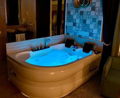 Foto de una de las románticas habitaciones con bañera de hidromasajes junto a la cama.