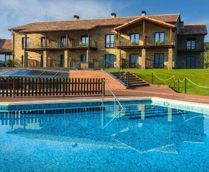 Hermoso hotel rural con amplios jardines y piscina al aire libre, ideal para una estancia en pareja.