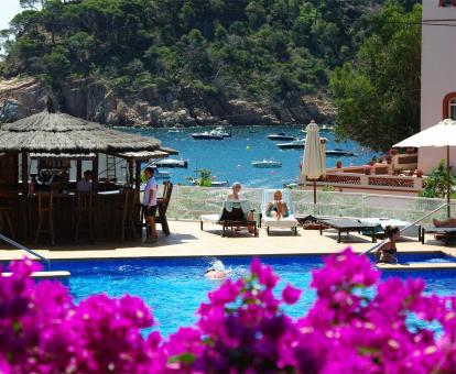Foto de la terraza al aire libre con piscina y bar con vistas al mar.