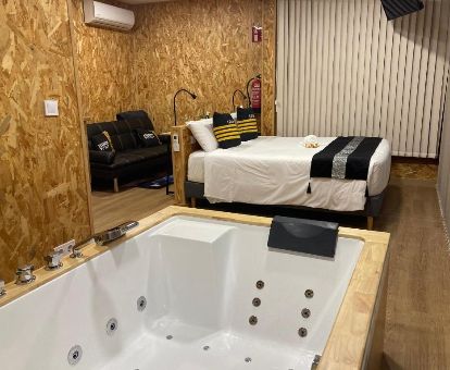 Una de las acogedoras suites con bañera de hidromasaje privada junto a la cama del hotel.