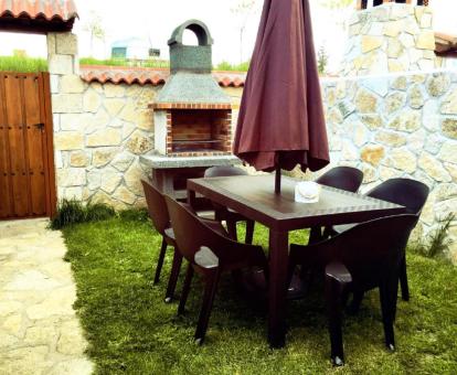 Foto del jardín privado con comedor exterior y barbacoa de la casa.
