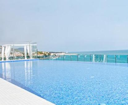 Foto de la piscina de la azotea con vistas al mar y camas balinesas.
