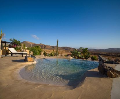 Maravillosa zona exterior con piscina de borde infinito en este hotel rural solo para adultos.