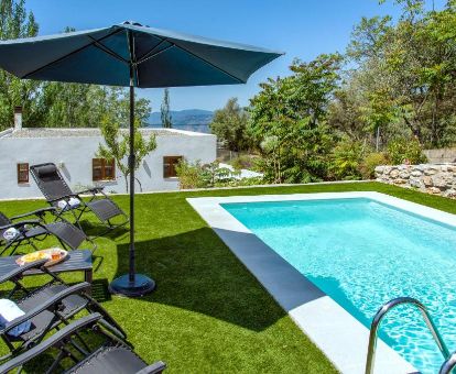 Hermosa zona exterior con amplios jardines y piscina privada de este alojamiento independiente en la naturaleza.