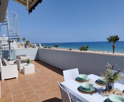 Foto de la terraza privada con comedor exterior y vistas al mar del apartamento.
