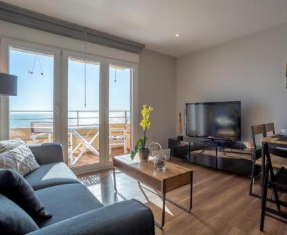 Foto del salón comedor con vista al mar desde apartamento con terraza.