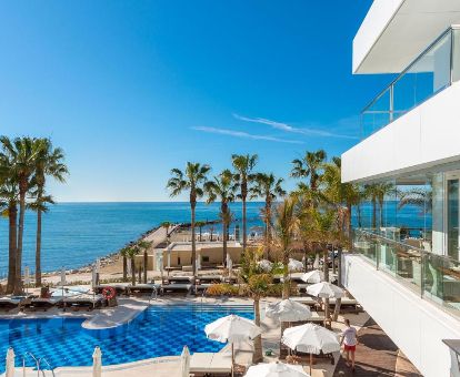 Zona exterior con piscina y mobiliario de este hotel en primera línea de playa.