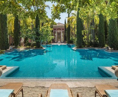 Hermosa piscina exterior rodeada de vegetación de este lujoso hotel ideal para parejas.