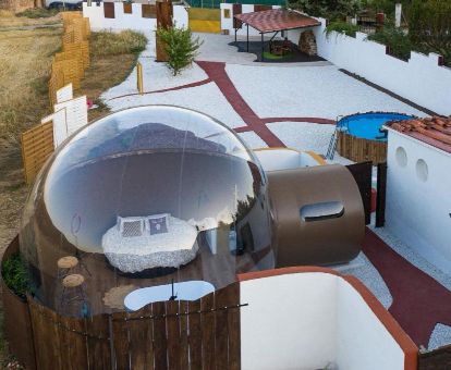 Habitación burbuja en una finca privada con piscina exterior.
