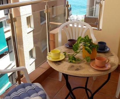 Foto del acogedor balcón con comedor exterior y vistas al mar del apartamento.