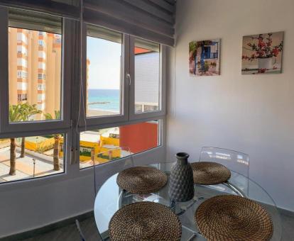 Foto del comedor con vistas al mar y a la ciudad de este apartamento.