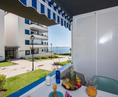 Foto del balcón con comedor y vistas al mar de este apartamento.