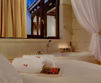 Foto de la habitación con jacuzzi privado cerca de la cama de los Apartamentos Muralla Zirí
